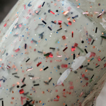 Load image into Gallery viewer, Color Code 0039: Creamsicle - Off white plastic with assorted shaped and sized red, orange, blue, copper, green, and black glitter